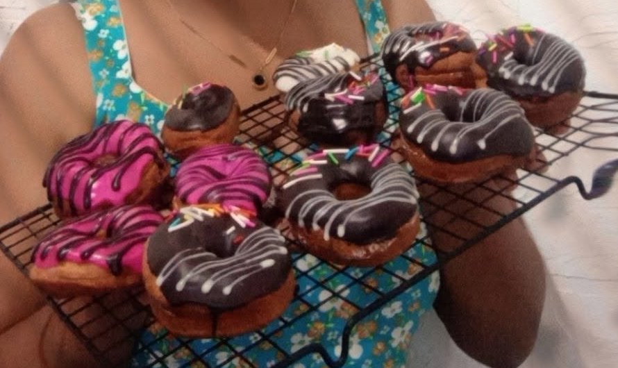 Chocolate and pink glazed donuts on a cooling rack