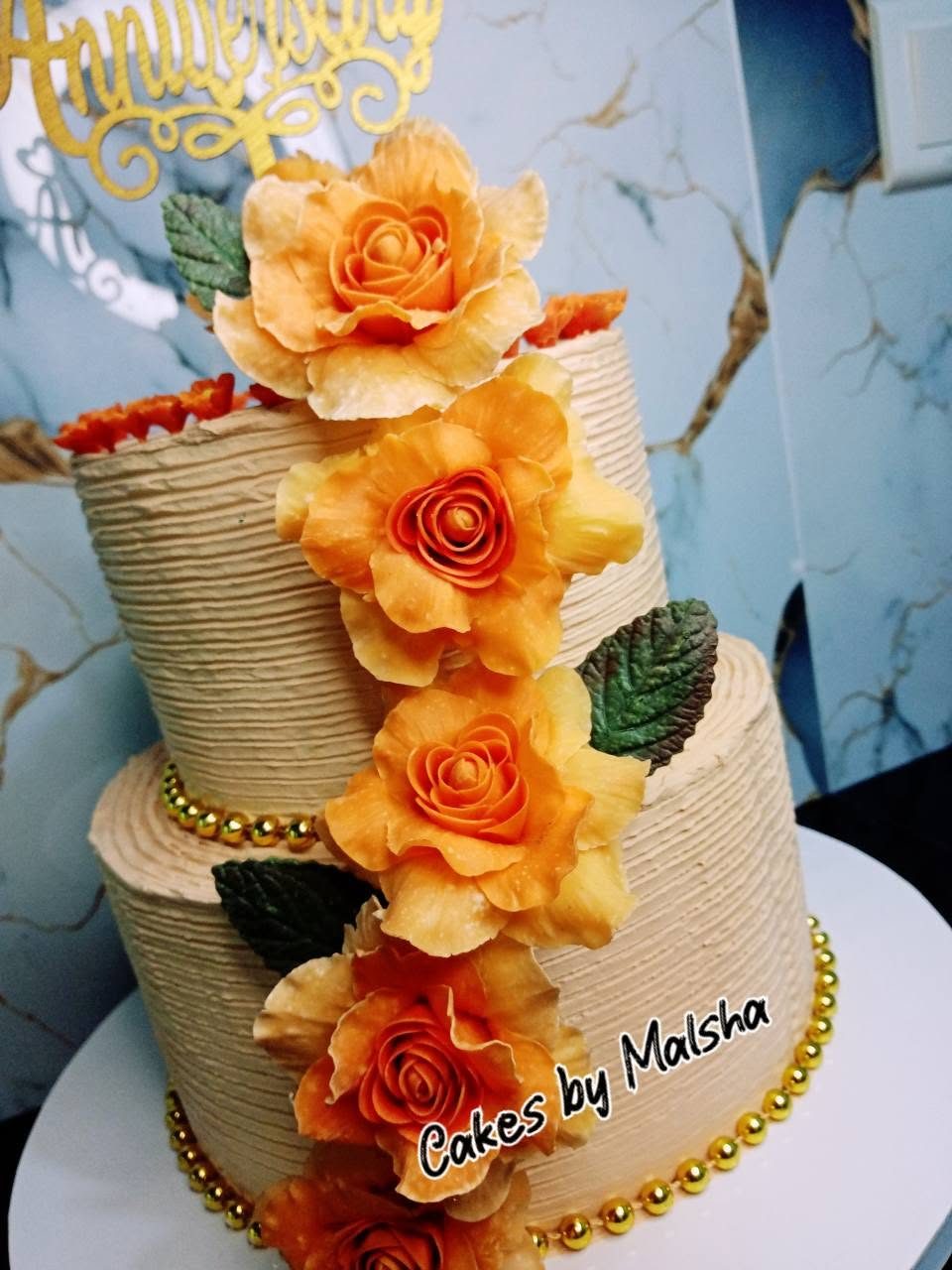 Two-tier anniversary cake with cascading peach sugar roses
