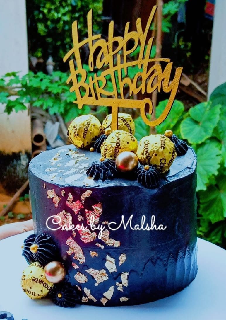 Navy and gold birthday cake with chocolates