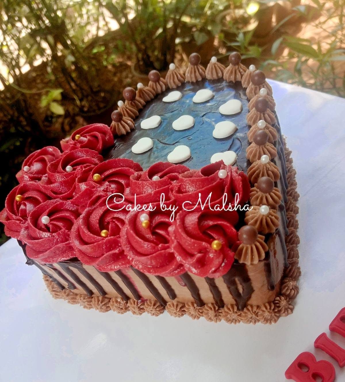 Heart-shaped cake with red buttercream roses