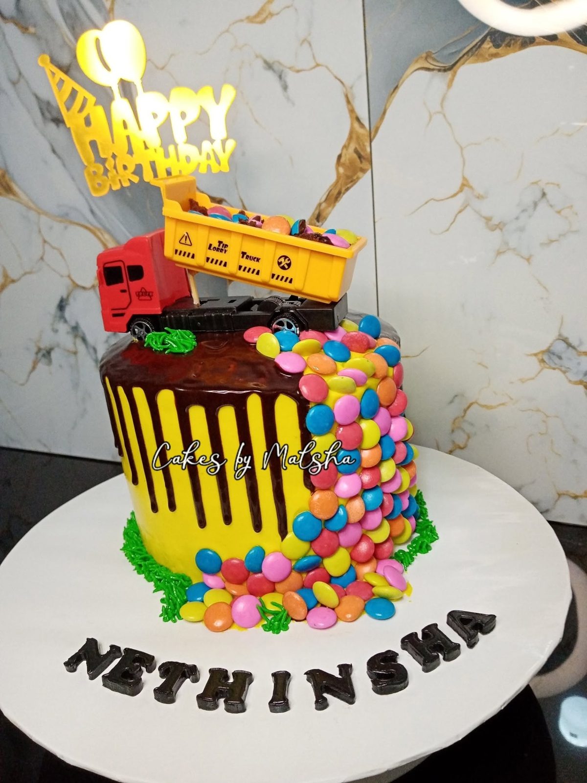 Truck-themed kids' birthday cake with sweets
