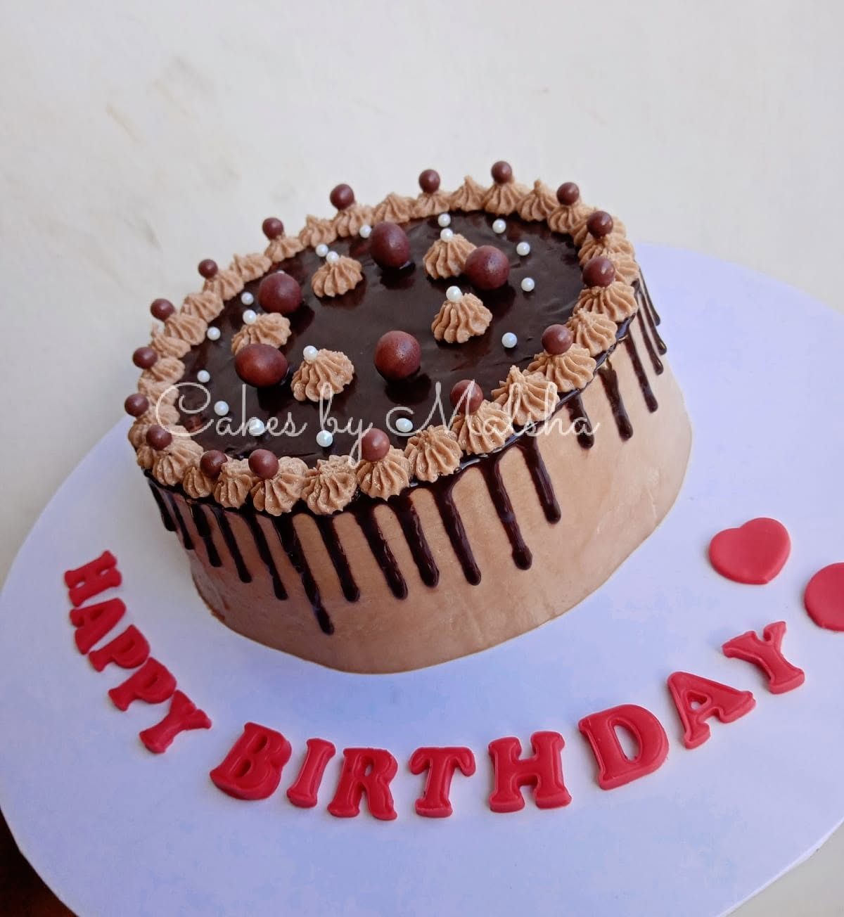 Chocolate drip birthday cake with chocolate balls